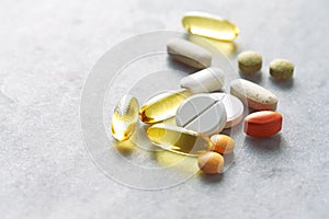 Assorted natural dietary supplements and vitamins on gray background