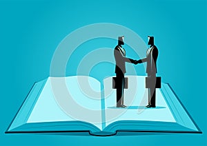 Symbolic image of two businessmen shaking hands while standing on the same page of an open book