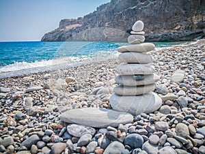 Symbolic scales of stones against the background of the sea and blue sky. Concept of harmony and balance. Pros and cons concept.