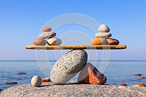 Symbolic scales of the stones against the sea. Pros and cons concept