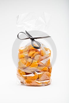 Symbolic scissors in ribbon cut a bag containing dried apricots