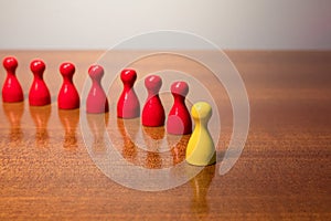 Symbolism wooden red and yellow figures for business exclusion racism mobbing hate religions