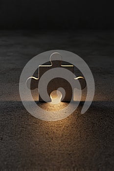 Single jigsaw puzzle piece with glowing light on dark textured background