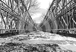 Symmetrical metal bridge with footpath from low perspective with