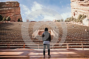 Symmetrical Portrait of Male Person Standing Front and Center on a Stage Dreaming and Imagining the Future while Facing Stadium St