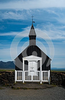 Symmetrical shot of black wooden church and gate on Snaesfellnes peninsula Iceland