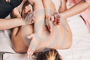 Symmetrical work of two massage therapists at the same time - effective relaxing four-hand massage