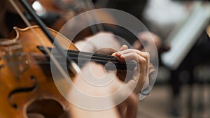 Symphony concert, a man playing the cello, hand close up