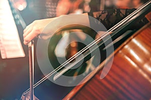 Symphony orchestra on stage, hands playing cello