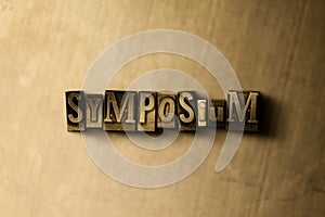 SYMPOSIUM - close-up of grungy vintage typeset word on metal backdrop photo
