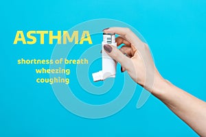 Symptoms of asthma. A woman`s hand holds an inhaler with medicine. Side view. Blue background with text