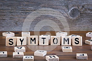 Symtoms from wooden letters on wooden background