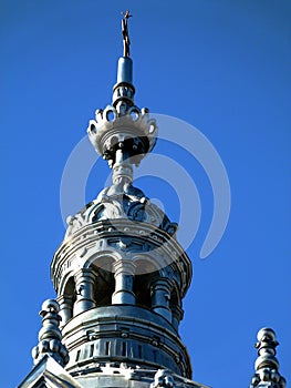 Synagogue building`s metallic grey zink tower under blue sky