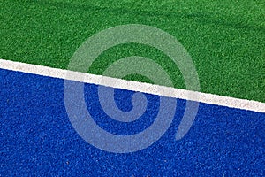 Synthetic hockey sideline closeup blue and green