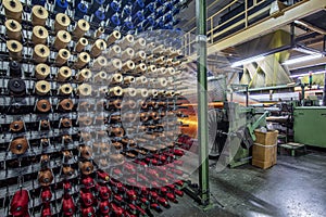 Synthetic yarns for carpet factory, carpet production, weaving looms. Interior of a Carpet Weaving Factory. Spool Sewing Thread