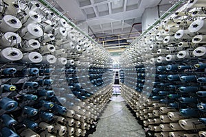 Synthetic yarns for carpet factory, carpet production, weaving looms. Interior of a Carpet Weaving Factory. Spool Sewing Thread