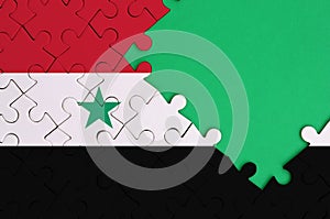 Syria flag is depicted on a completed jigsaw puzzle with free green copy space on the right side