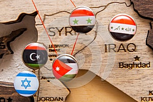 Syria, Iraq, Israel, Libanon, Iran flags on the push pins and red thread on the wooden map, close up