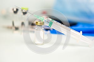 Syringe with ampoule of medicine on blurred medical background. treatment, prevention, laboratory, infection. soft focus. copy