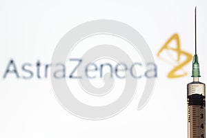 Syringe and AstraZeneca logo on the background. Coronavirus, Covid-19 vaccine concept