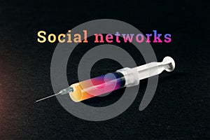 Syringe on a black background and the word social network. The concept of dependence on social networks, an internet addict