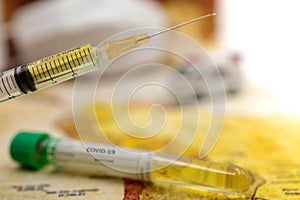 Syringe of COVID-19 vaccine on ambulance car with medical mask and world map background .