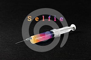 A syringe on a dark background and the word selphi. The concept of mania, Internet addiction