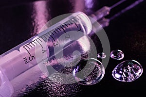 Syringe and few drops of liquid on metal surface