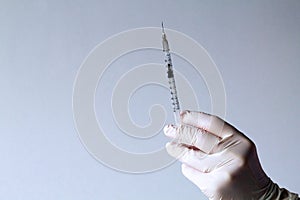 Syringe in hand isolated on a light background