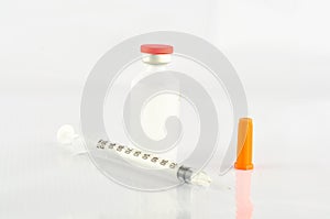 Syringe and insulin vial on white background