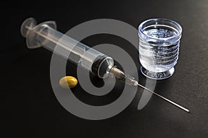 Syringe with liquid medicine container on black