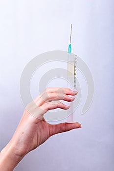 Syringe, medical injection in hand, palm or fingers. Medicine plastic vaccination equipment with needle. Nurse doctor