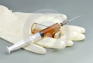 Syringe with medicine, ampoule and medical gloves.