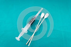 Syringe with medicine and cotton on green background