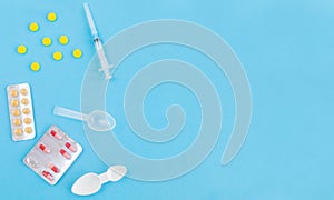 Syringe and medicine pills, capsules on blue background.Concept of medicine.Medicines for the treatment of diseases