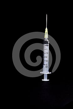 Syringe with needle on black background