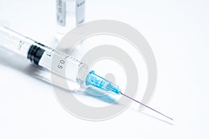 Syringe with needle and cover or top, vial or phial on a white empty space background
