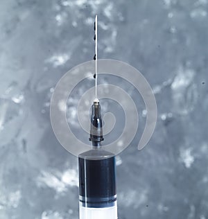 A syringe with a needle filled with crude oil