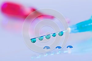 Syringe needle with green fluid drops