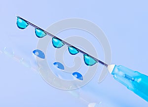 Syringe needle with green fluid drops