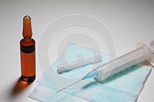 Syringe with the needle on hygienic napkin and ampule