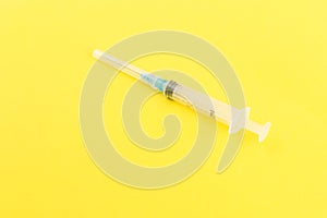 Syringe and needle isolated on yellow background. The concept of medicine.Medicines for the treatment of diseases