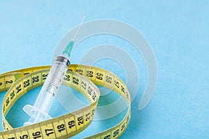 Syringe with a needle and measuring tape. Injections for body beauty and weight loss. Drug for muscle growth of bodybuilders