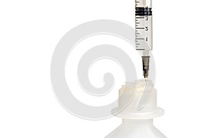 A syringe with a needle stuck in a plastic bottle. Objects are isolated on a white background. Saline bottle. Medicine and