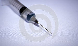 Syringe with one drop on the tip, medical background