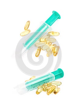 Syringe over pile of pills isolated