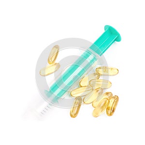 Syringe over pile of pills isolated