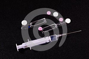 Syringe and pills on a black background. Healthcare and medicine concept
