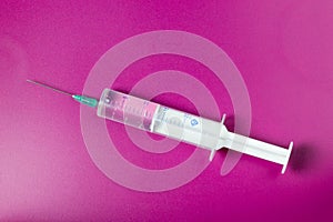 Syringe on a pink background