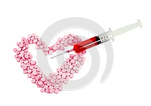 Syringe and pink pills form heart shape